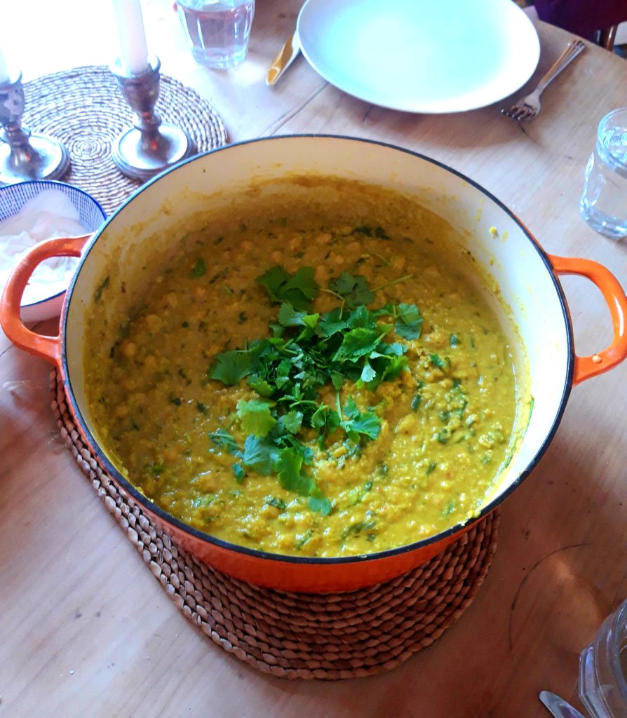 Photo shows a pot of dahl made with coconut, courgette and spinach - the dahl is a green colour.