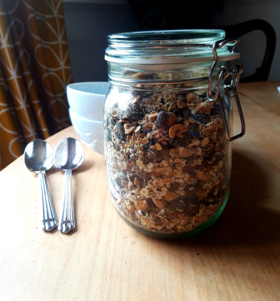 Photo of a glass jar full of muesli on the kitchen table