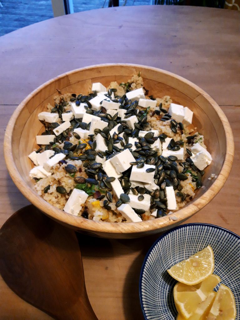 Image shows a bowl of salad made using bulgur wheat, squash, feta cheese and seeds