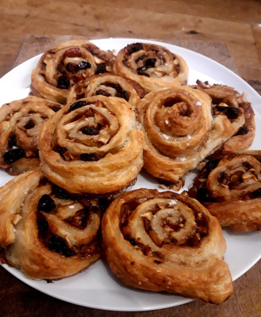 A plate piled with apple and cinnamon swirls.