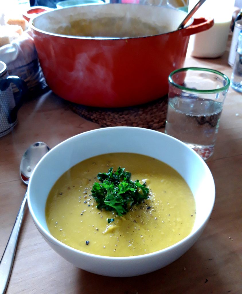 A photo of a steaming bowl of green split pea soup.