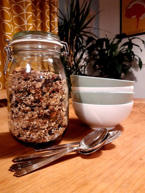 Dining table with jar of granola,spoons and bowls