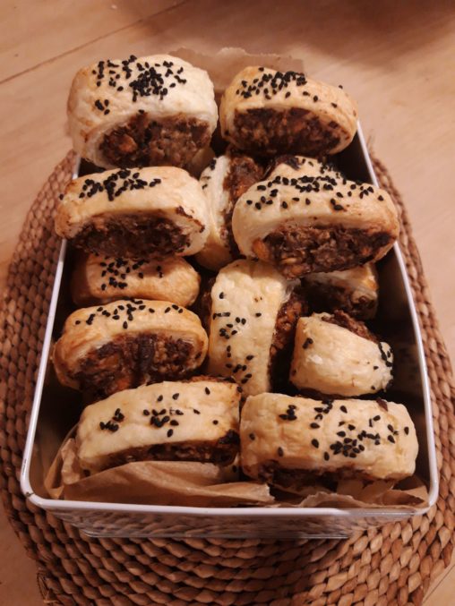 An oven dish piled high with small vegetable sausage rolls