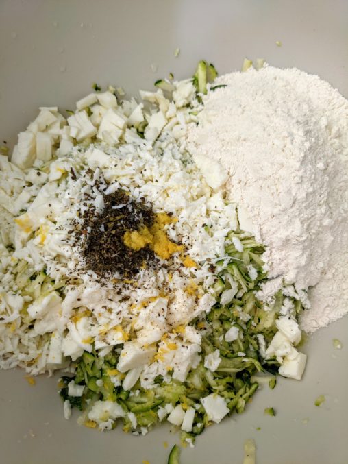 A mound of dry ingredients of vegetables and flour on a table surface ready to be mixed