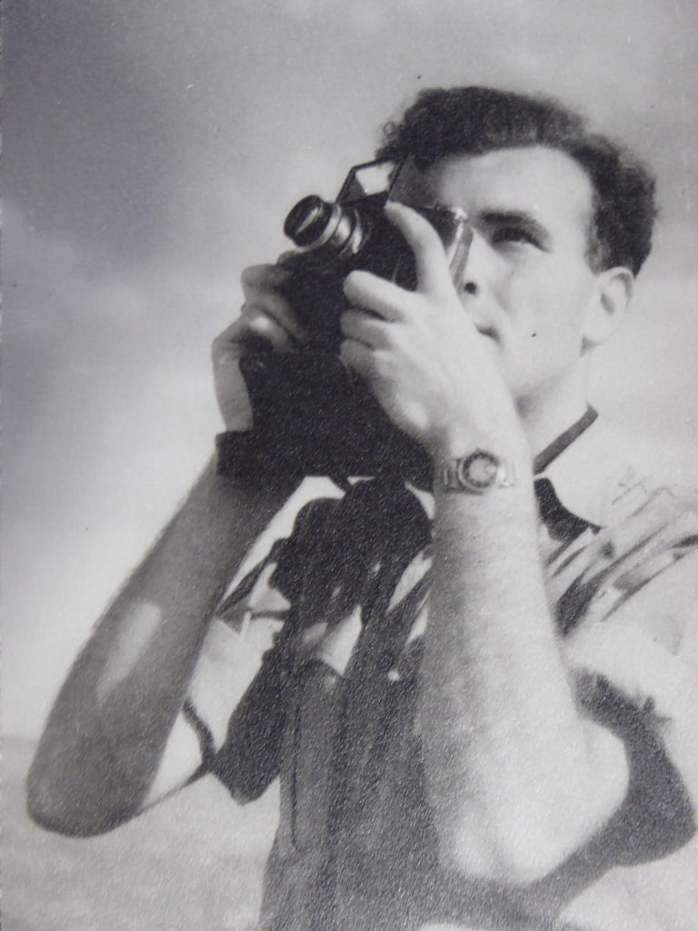 black and white photograph showing Ross Eudal with a camera to his eye.
