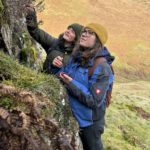 Two female botanists looking at a crag as possible oblong woodsia habitat