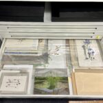 Photography of artworks held in a drawer in a metal cabinet