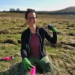 Woman planting an elm sapling for a conservation project